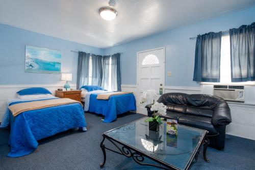 a room with two beds and a couch and a table at Wilshire Motel in Los Angeles