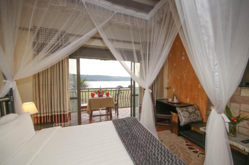 a bedroom with a bed and a balcony at Victoria Forest Resort in Kalangala