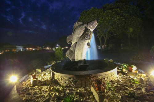 a statue in front of a fountain at night at Victoria Forest Resort in Kalangala