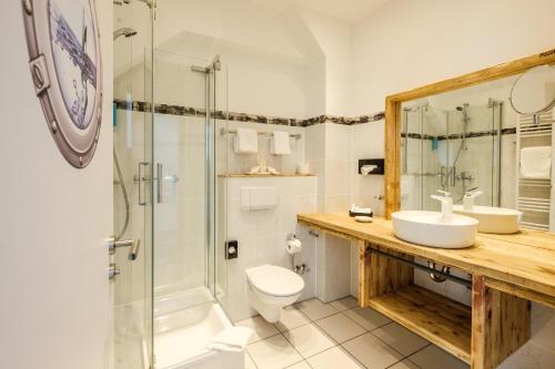 a bathroom with a toilet sink and a shower at Das 53°Hotel in Bad Zwischenahn