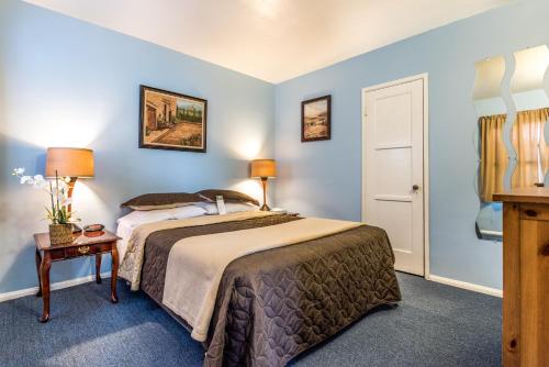 a bedroom with a large bed with blue walls at Wilshire Motel in Los Angeles