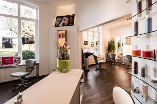 a salon with chairs and a counter with flowers on it at Das 53°Hotel in Bad Zwischenahn