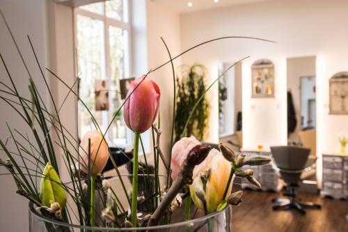 a vase filled with flowers on a table at Das 53°Hotel in Bad Zwischenahn