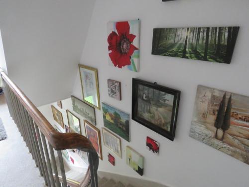 a wall with paintings and pictures on a staircase at Mill House Apartment and Camping in Ljutomer