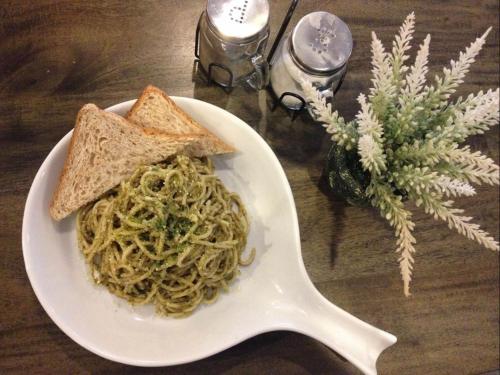 a white plate of pasta with bread and toast at Pillows Hotel Cebu in Cebu City