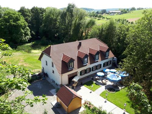 una vista aérea de una casa con patio y mesas en Gästehaus Alte Klostermühle, en Gräfinthal