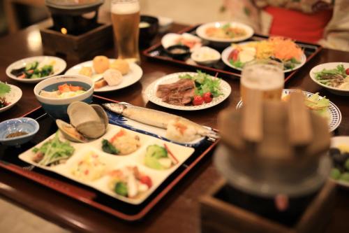 a table with many plates of food on it at Hotel Koyokan in Hanamaki