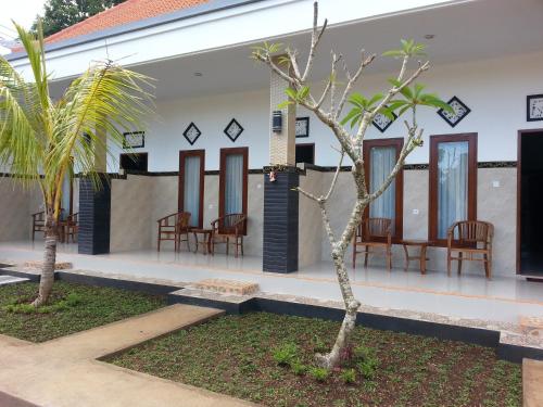 a view of the courtyard of a house with chairs and trees at Ega Homestay in Nusa Penida