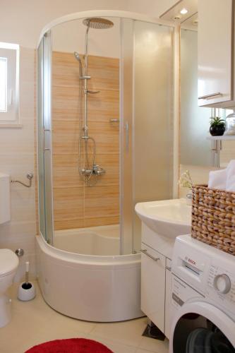 a bathroom with a shower and a toilet and a sink at Happy garden house in Kožino