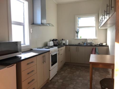 a kitchen with white cabinets and a stove top oven at Harbourview Stadium Hotel in Dunedin