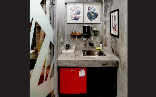 a small kitchen with a sink and a red dishwasher at Phuket Paradiso in Chalong 