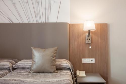 
a bedroom with a bed and a lamp at Hostal Centric in Barcelona
