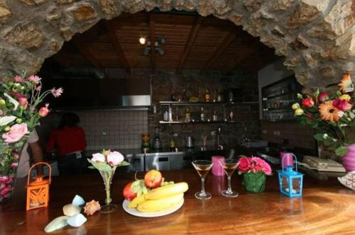 a table with a plate of bananas and wine glasses at Villa Harmony in Agia Anna Naxos