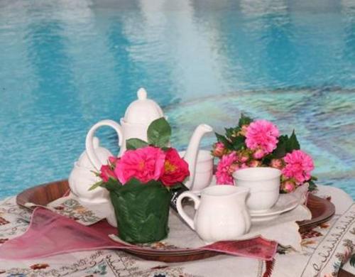 a table with a tea set and flowers on it at Villa Harmony in Agia Anna Naxos