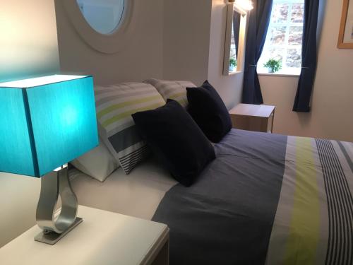 a bedroom with a bed with a blue lamp at Beachside - North Berwick in North Berwick