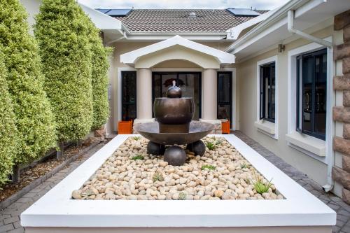 a fountain in the courtyard of a house at Orange Inn Knysna in Knysna