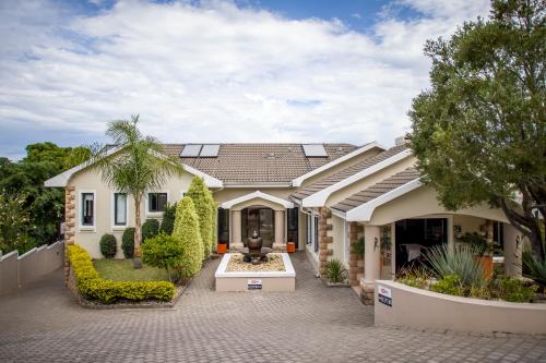 a house with a courtyard in front of it at Orange Inn Knysna in Knysna