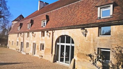 an old brick building with a large door at Domaine de Surgy in Surgy