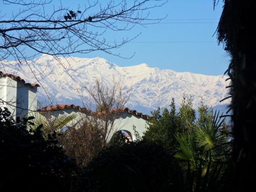 a snow covered mountain in the distance with a house at Cuore Verde in Cavour