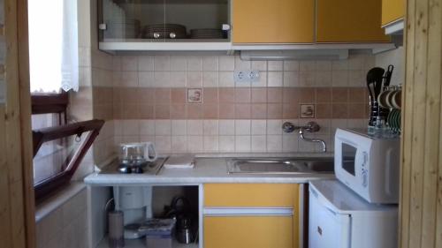 a small kitchen with a sink and a microwave at Levendula Ház in Lipót
