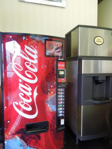 a coca cola vending machine next to a popcorn machine at Red Carpet Inn Brooklyn in Brooklyn