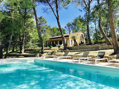 a pool with chairs and a house in the background at Zen et Chic, juste à coté de la Bastide de Marie in Ménerbes