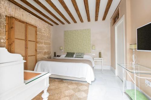 a bedroom with a white bed in a room at Hotel Casa de las Cuatro Torres in Cádiz