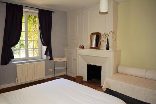 a bedroom with a bed and a fireplace and a window at Petite Roche gîtes centre-ville La Rochelle in La Rochelle