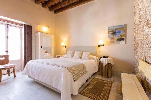 a bedroom with a large white bed in a room at Hotel Casa de las Cuatro Torres in Cádiz