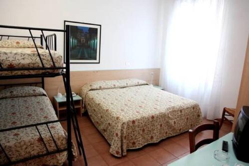 a bedroom with two bunk beds and a television at Albergo Rondò in Acqui Terme