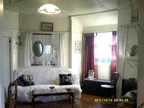 a bedroom with a bed and a chair and a window at Monday Seaside Cottage in Whanganui