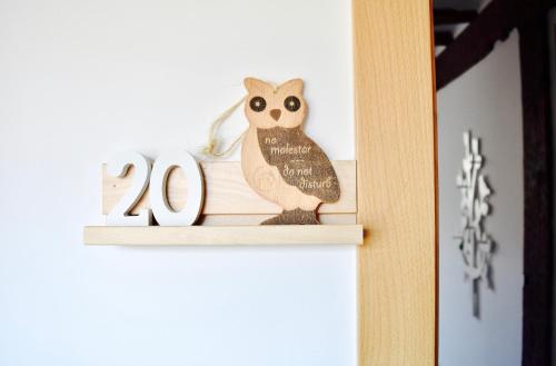 an owl ornament on a shelf with a sign at Apartamentos Turísticos Rincones del Vino in Ezcaray