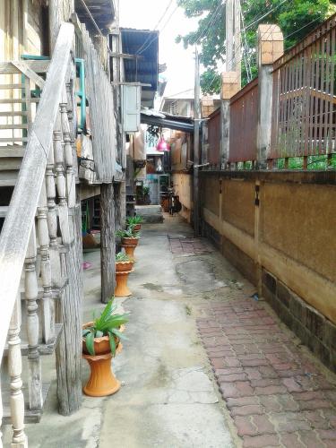 an alley with potted plants on the side of a building at Ray Nu Guest House in Phra Nakhon Si Ayutthaya