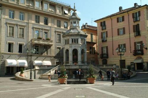 a building with a clock tower in the middle of a street at Albergo Rondò in Acqui Terme