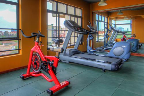 a gym with three exercise bikes in a room at Highlands Suites Hotel Apartments in Nairobi