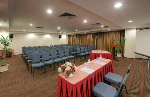 ein Konferenzraum mit Tischen und Stühlen und einer Leinwand in der Unterkunft Crystal Crown Hotel JB in Johor Bahru