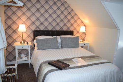 1 dormitorio con 1 cama grande y 2 mesitas de noche en The Tables Guest House en Dunvegan