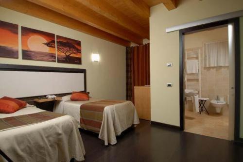 a hotel room with two beds and a bathroom at Hotel Villa Altura in Ospedaletto Euganeo