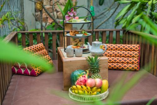 a table topped with plates of food and fruit at Mekong Angkor Deluxe Hotel in Siem Reap