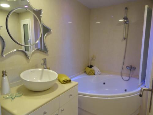 Ground Floor Sea View في سيتجيس: حمام مع حوض ومغسلة ودش