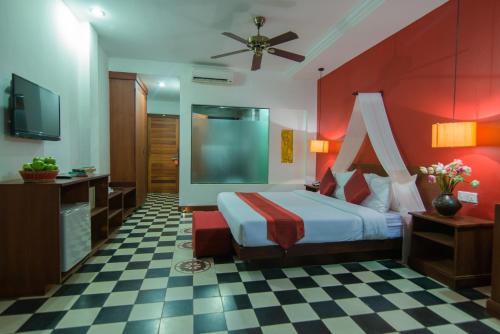 a hotel room with a bed and a flat screen tv at Mekong Angkor Deluxe Hotel in Siem Reap
