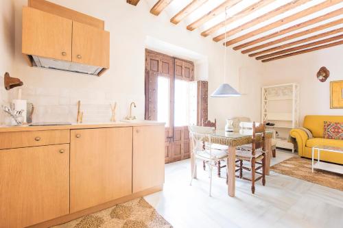 a kitchen and living room with a table and a couch at Hotel Casa de las Cuatro Torres in Cádiz