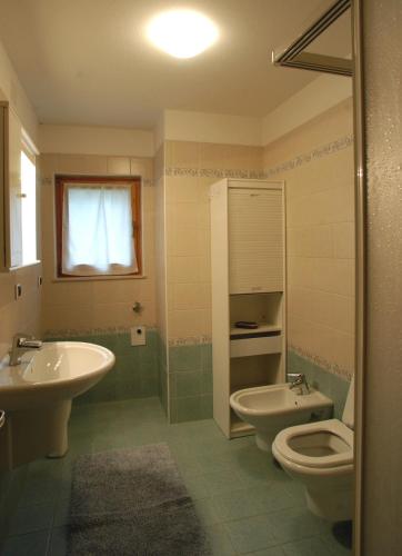 a bathroom with a sink and a toilet and a sink at Casa De Biasio PM in Falcade