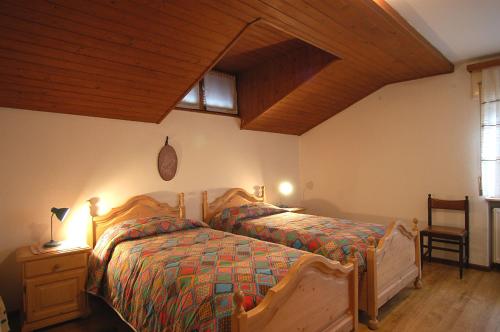 a bedroom with a bed and a wooden ceiling at Casa De Biasio PM in Falcade