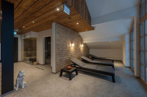 a living room with couches and a brick wall at Gasthaus - Hotel FUCHS in Mauth