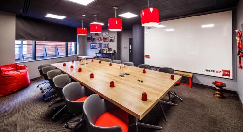 a conference room with a large wooden table and chairs at ibis Birmingham Centre New Street Station Hotel in Birmingham