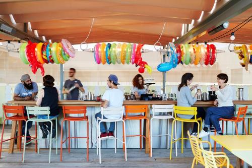 a group of people sitting at a bar in a restaurant at Mama Shelter Bordeaux Centre in Bordeaux