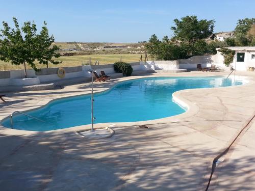a large swimming pool with blue water in a yard at Cueva Las Yeseras in Baza