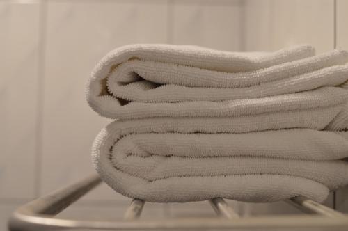 a stack of towels sitting on top of a towel rack at UD Capital Hotel in Udon Thani