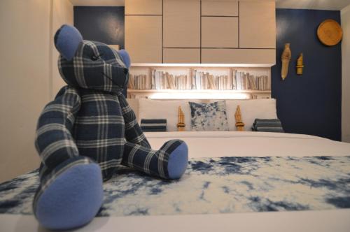 a teddy bear sitting on a bed in a bedroom at UD Capital Hotel in Udon Thani
